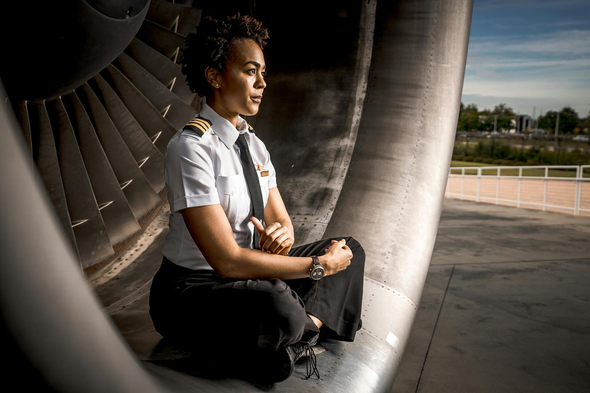 Woman Wearing Uniform Sitting inside an Aircraft Engine Intake
